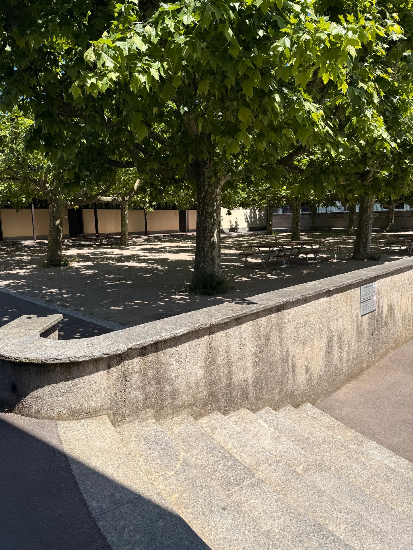 Mauer und Picknicktische im Innenhof der WMS